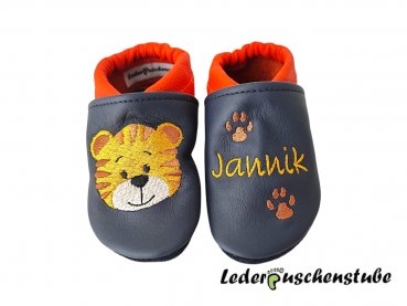 Lederpuschen dunkelblau-orange mit rechts Stickerei Tigergesicht maisgelb-braun-creme-schwarz und links Namen maisgelb mit 2 Tatzen braun